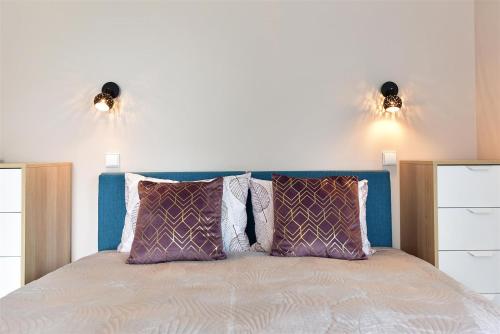 a bedroom with a bed with two lights on the wall at Svajonių Dvaras in Balninkai