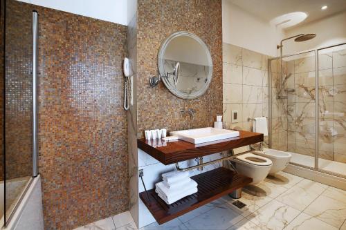 a bathroom with a sink and a shower and a toilet at Victor Hotel in Pervouralsk