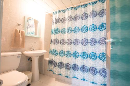 a bathroom with a toilet and a shower curtain at DebbieXenia Hotel Apartments in Protaras