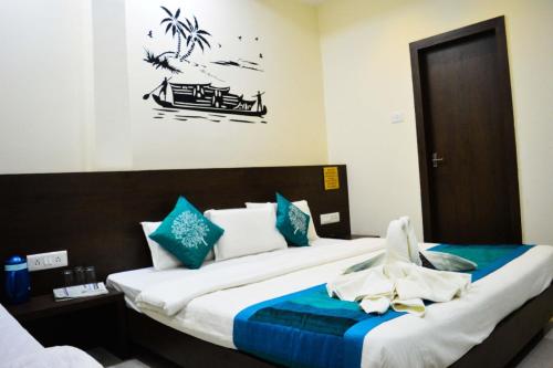 a bedroom with a large bed with blue and white pillows at Hotel Satyug in Ujjain