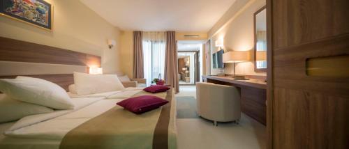 a hotel room with two beds and a kitchen at Hotel Park Makarska in Makarska