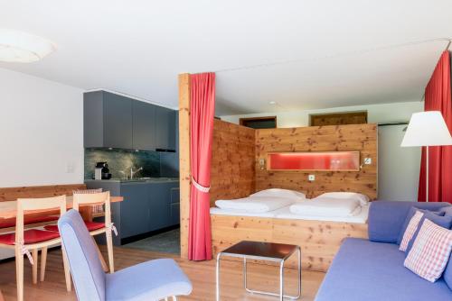 Habitación de hotel con cama, mesa y sillas en Hapimag Ferienwohnungen Andeer en Clugin