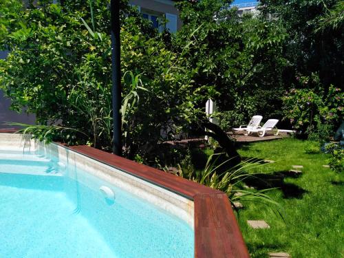 - une piscine dans une cour avec 2 chaises blanches dans l'établissement Villa 3 room AC garden pool parking 2 min beach by car, à Cannes