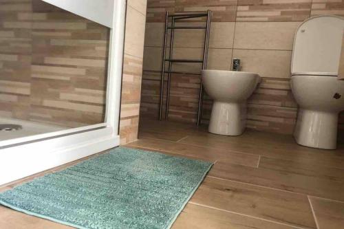 uma casa de banho com um WC, um chuveiro e um tapete. em Nicole Maison em Iesi