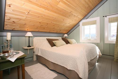 a bedroom with a bed and a wooden ceiling at Korsholmen - by Classic Norway Hotels in Karvåg