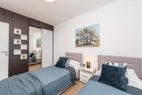 a bedroom with two beds and a mirror at Mediteran luxury penthouse with jacuzzi in Mandre