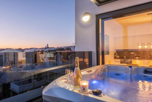 a bath tub with a bottle of champagne on a balcony at Mediteran luxury penthouse with jacuzzi in Mandre