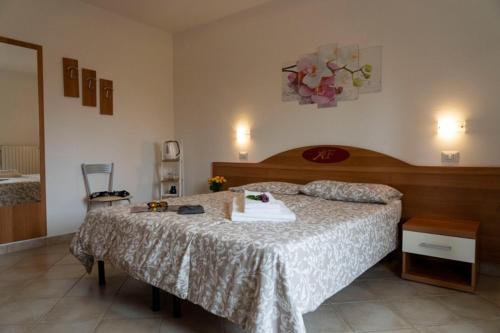 トレモージネ・スル・ガルダにあるAgriturismo Al Franetのベッドルーム1室(大型ベッド1台、木製ヘッドボード付)