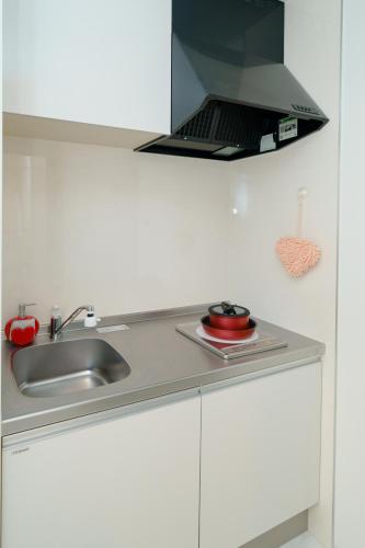 a kitchen with a sink and a stove at Osaka Yeon House in Osaka