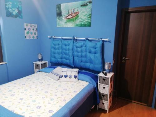 a blue bedroom with a bed and a boat in the water at B&B Villa Anita in Bellano