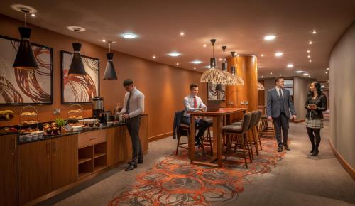 a group of people standing around a table in a kitchen at Clayton Hotel Belfast City in Belfast