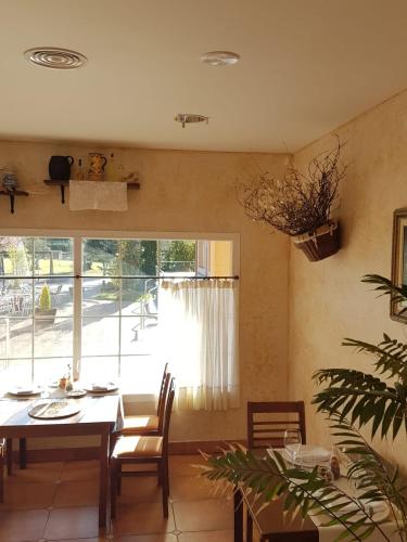 a dining room with a table and a large window at Hotel Restaurante La Alhama in Medina de Pomar