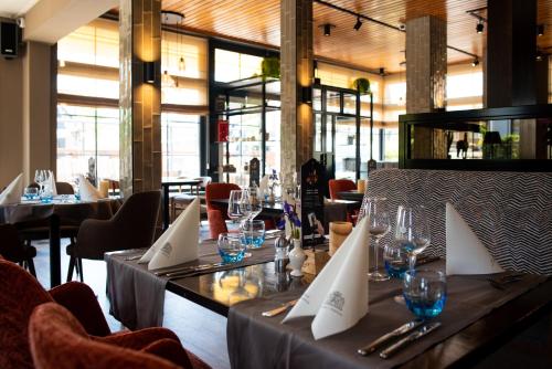 a restaurant with a table with glasses and napkins at Hotel Het Wapen van Drenthe in Roden