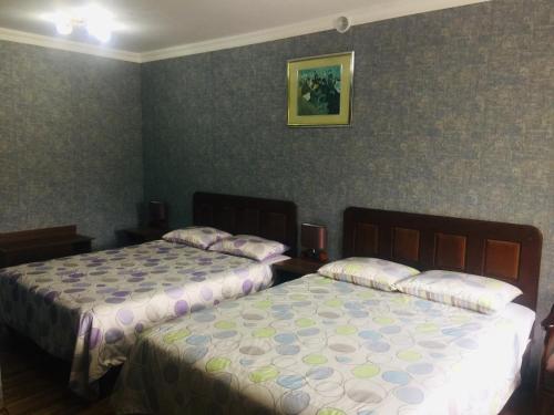 two beds in a hotel room with two bedsskirts at Cinzano Complex in Samarkand