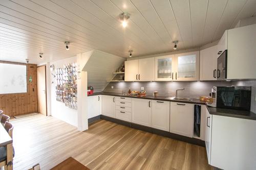 a kitchen with white cabinets and a wooden floor at Hof-Tschannen in Lengwil