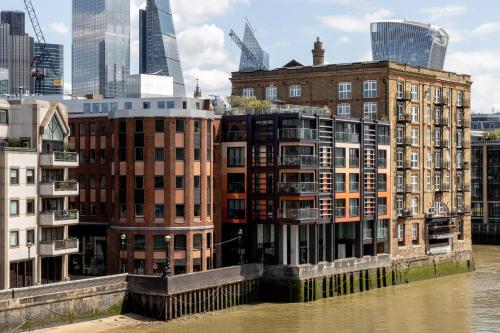 un groupe de bâtiments à côté d'une rivière dans l'établissement Locke at Broken Wharf, à Londres