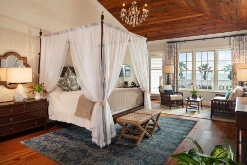 a bedroom with a canopy bed with a blue rug at Port d'Hiver Bed and Breakfast in Melbourne Beach