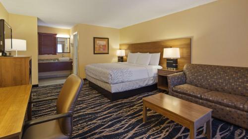 a hotel room with a bed and a couch at Best Western Mountainbrook Inn Maggie Valley in Maggie Valley