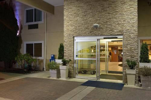 a glass door of a building with potted plants at Holiday Inn Express Hotels & Suites Burlington by IHG in Burlington