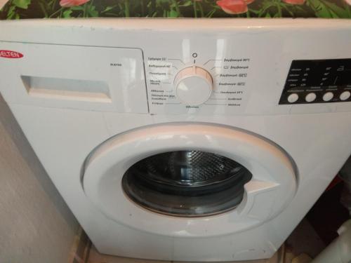 a white washing machine with its door open at Ktima Tzamika in Episkopi