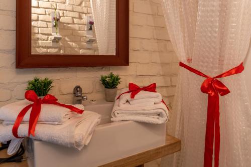 un baño con toallas con arcos rojos en un lavabo en Sinanis Garden House, en Volos