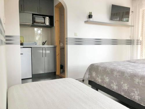 um pequeno quarto com 2 camas e uma cozinha em Pearl Home Siofok em Siófok