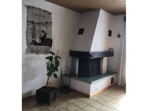 a living room with a fireplace and a potted plant at Ferienhaus Somareiva in Savognin