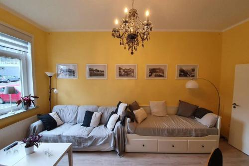 a living room with a couch and a chandelier at Ehem. Berg Apotheke in Sankt Andreasberg