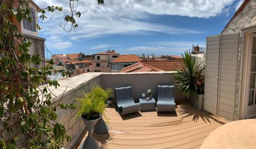 a balcony with two blue chairs on a wooden deck at Apartment Luxury Palace No1 in Split