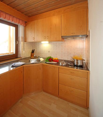 a kitchen with wooden cabinets and a sink at Residence Sas Vanna in La Villa