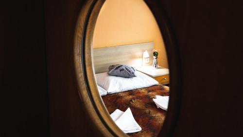 a bedroom with a bed and a mirror at Hotel and Park Divoká Voda in Bratislava