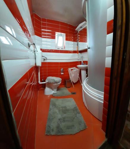 a red and white bathroom with a toilet and a tub at Noa.s Pansion 88 in Vrnjačka Banja