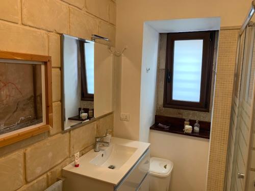 a bathroom with a sink and a toilet and a window at OpenSpace Beneventano in Scicli