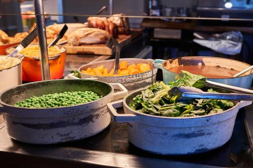 a group of pots filled with vegetables on a counter at The Tap House in Ashby de la Zouch