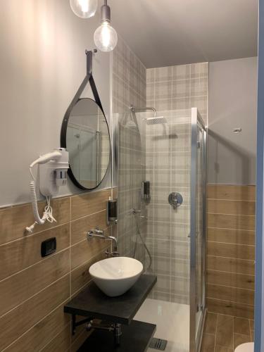 a bathroom with a sink and a shower with a mirror at MARCONI 2 rooms in Bologna