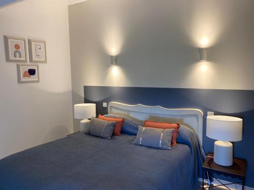 a bedroom with a blue bed with two pillows at Auberge de la Tour de Brison in Sanilhac