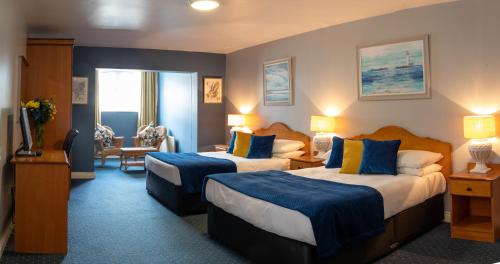 Murphy's Hotel في Tobercurry: غرفة فندق بسريرين مع وسائد زرقاء وصفراء