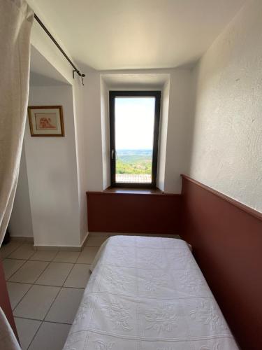 a bedroom with a bed and a window at Auberge de la Tour de Brison in Sanilhac