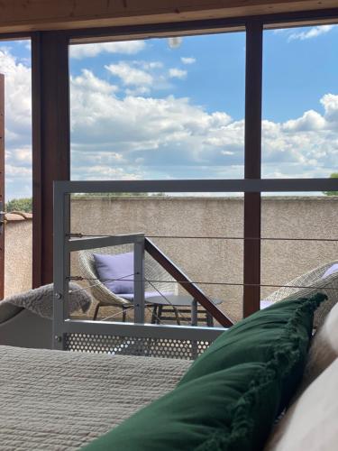 a room with a bed and a view of a balcony at Auberge de la Tour de Brison in Sanilhac