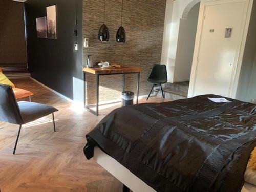 a bedroom with a bed and a desk with a chair at Herberg Restaurant 't Zwaantje in Mook