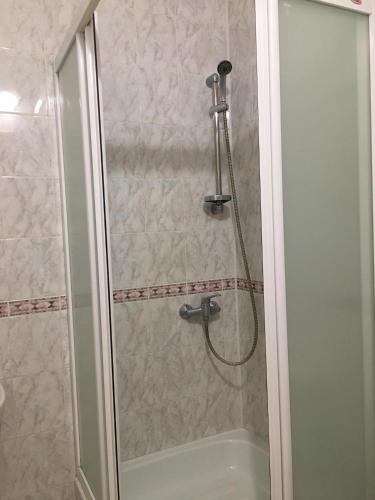 a shower with a shower head and a bath tub at Šeduvos malūnas in Šiauliai