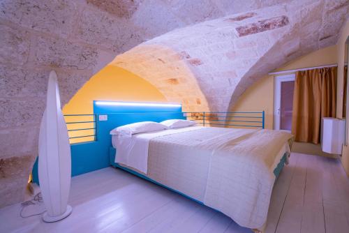 a bedroom with a bed and a surfboard in it at Al Giardino Del Nespolo in Polignano a Mare