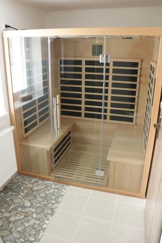 um chuveiro com uma porta de vidro na casa de banho em Apartmány u Beka em Loučná nad Desnou