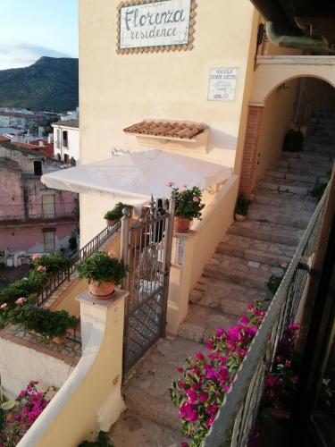 an outdoor staircase with a white umbrella and flowers at Florenza Residence in Sperlonga