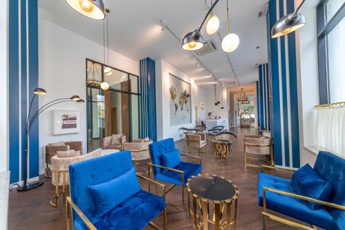 una sala de espera con sillas y mesas azules en Newport Hotel Kutaisi, en Kutaisi