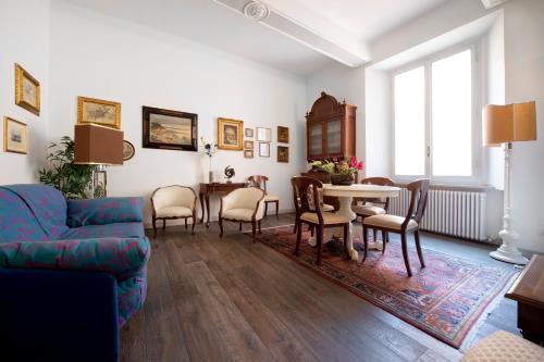 a living room with a couch and a table and chairs at UR-NEST De' Fusari in Bologna