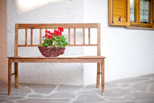 a wooden bench with a basket of flowers on it at Ferienwohnungen Trogerhof in Ora/Auer