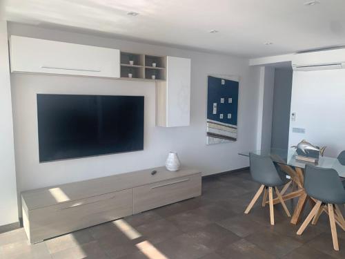 uma sala de estar com uma televisão de ecrã plano na parede em Calafell Torre Sol 4 em Calafell