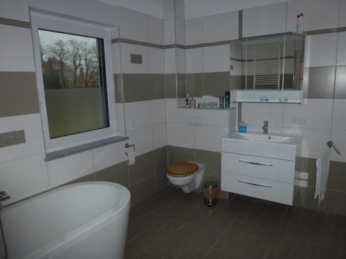 a white bathroom with a toilet and a sink at Ferienoase an der Wublitz in Potsdam