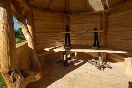 un interior de una cabaña de madera con dos mesas. en Camp The sunrise hill, en Pivka
